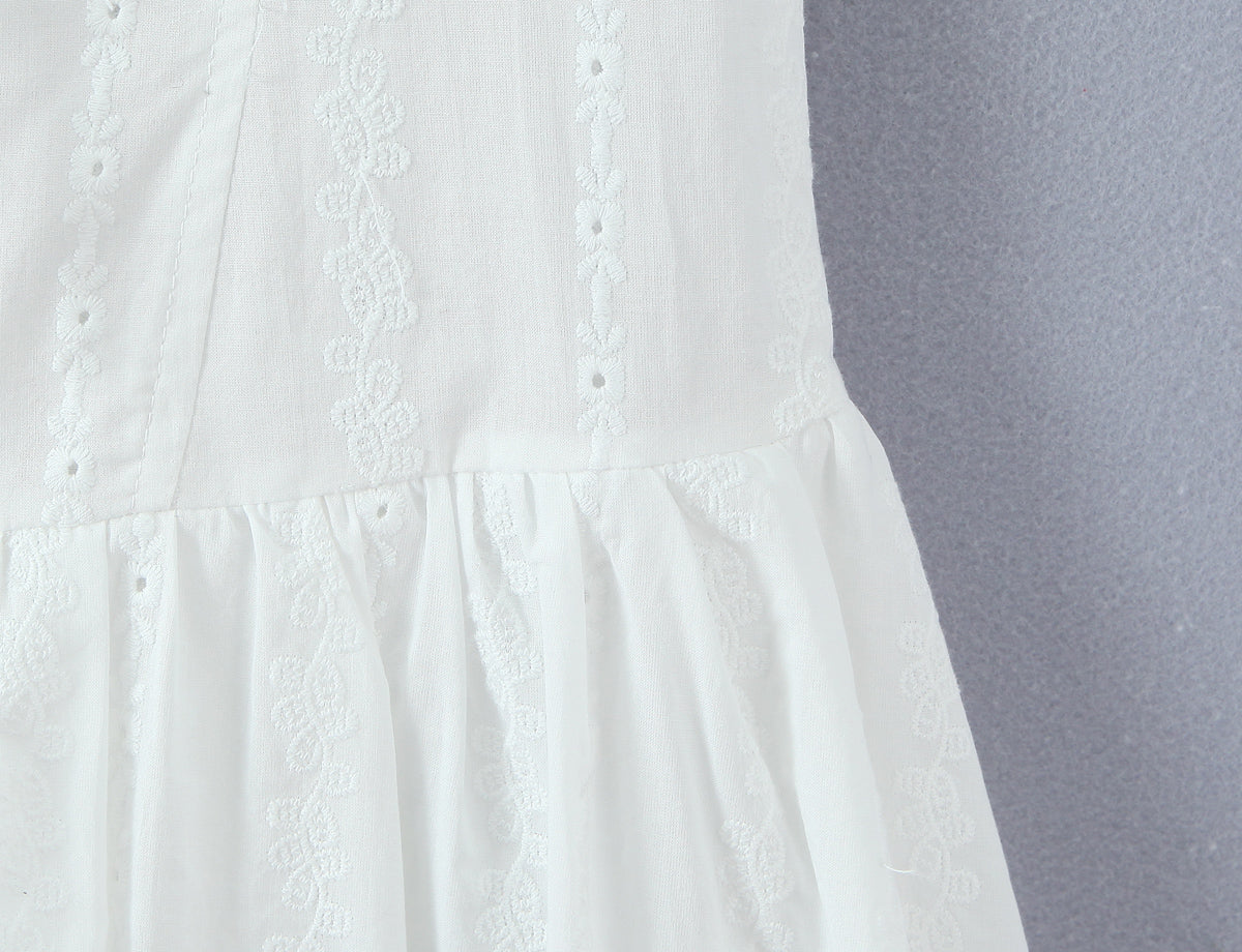 White dress with lace detailing on a gray background