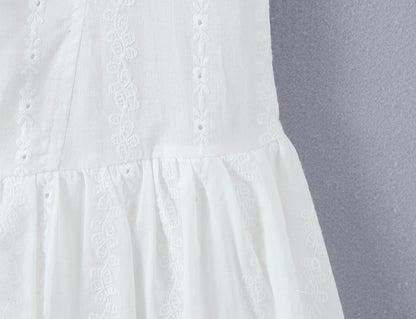 White dress with lace detailing on a gray background