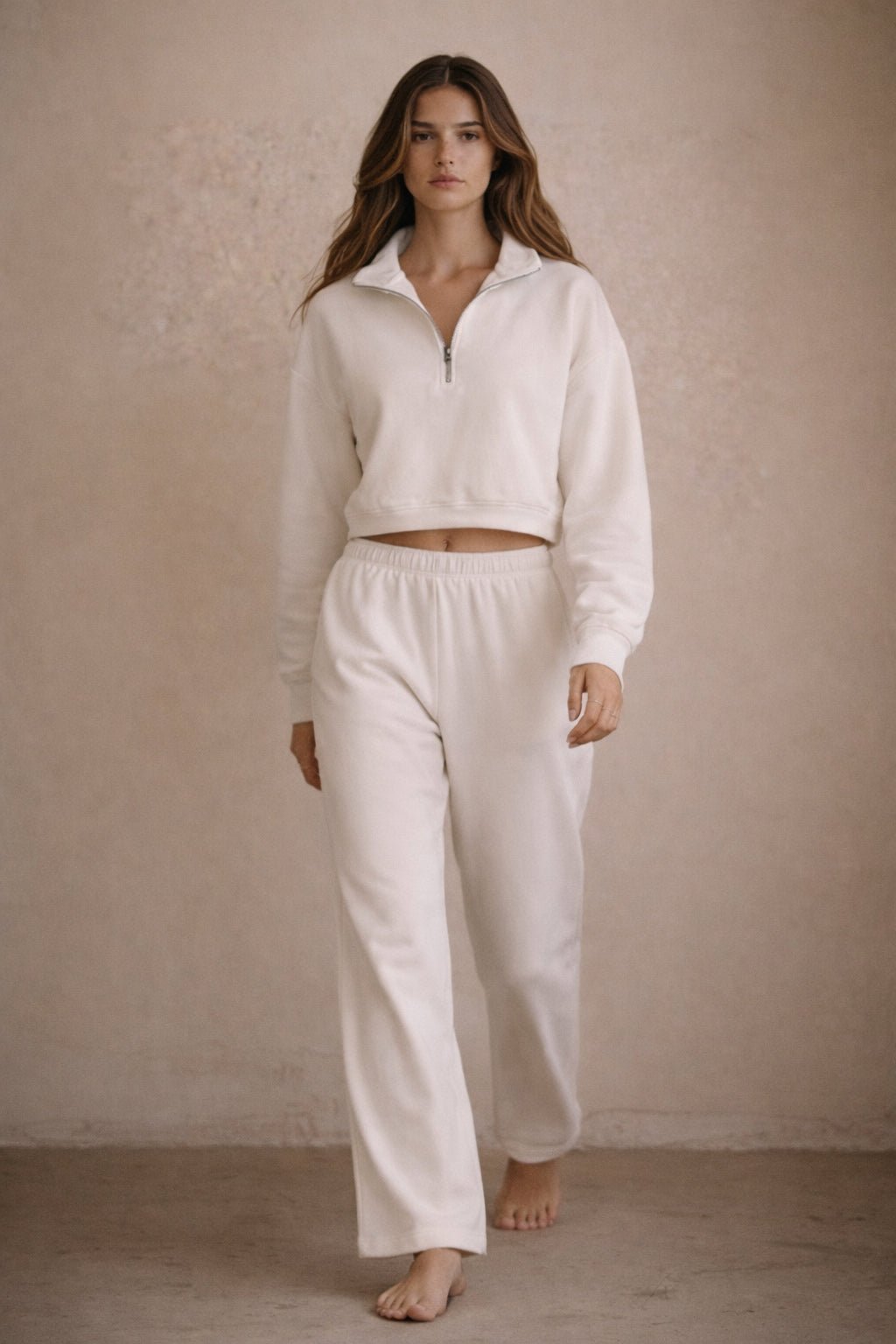Woman wearing a white outfit against a beige background