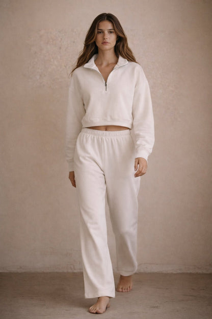 Woman wearing a white outfit against a beige background